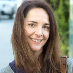 jeune femme brune aux longs cheveux en train de sourire